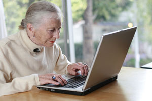 Elderly woman working on laptop computer