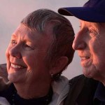 Happy senior couple watching sunset.