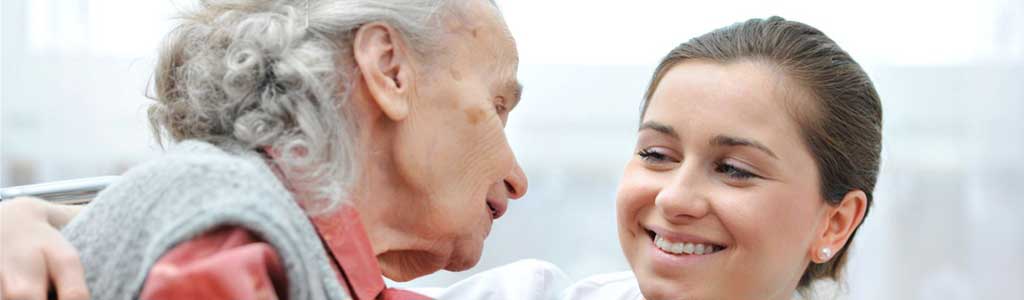 Senior woman and young caregiver talking.