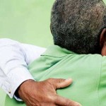 Two senior men hugging.