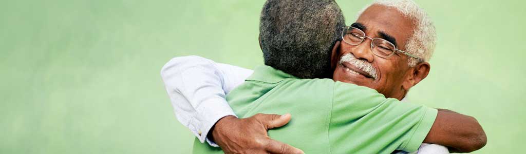 Two senior men hugging.