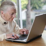 Elderly woman working on laptop computer