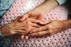 Image of caregiving holding hands with elderly woman