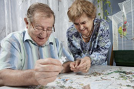 Older couple working on jigsaw puzzle together