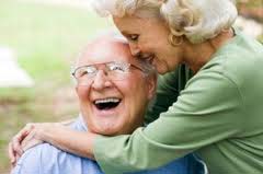 Image of laughing older couple hugging
